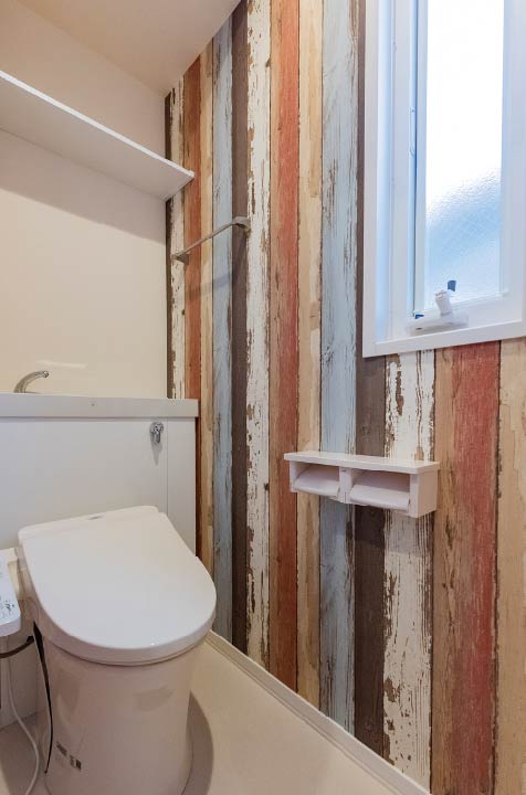 東京セキスイハイム建築実例_カラフルな木目調のアクセントクロスが印象的なトイレ
